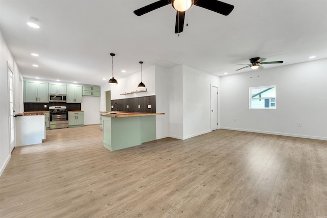 kitchen featuring light hardwood / wood-style flooring, tasteful backsplash, green cabinetry, and stainless steel appliances