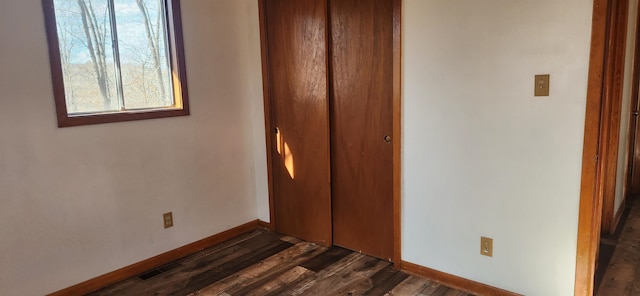 unfurnished bedroom featuring dark hardwood / wood-style floors and a closet