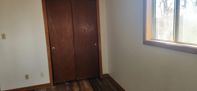 unfurnished bedroom featuring dark hardwood / wood-style flooring and a closet