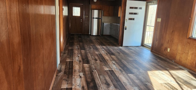 hall featuring dark hardwood / wood-style flooring and wooden walls