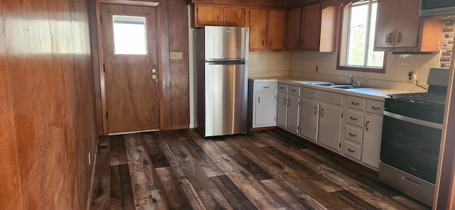 kitchen with decorative backsplash, stainless steel appliances, dark wood-type flooring, sink, and white cabinets