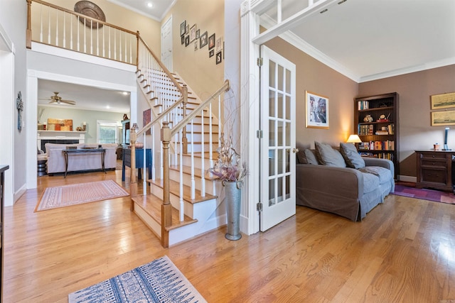 stairs with hardwood / wood-style floors, ceiling fan, and crown molding