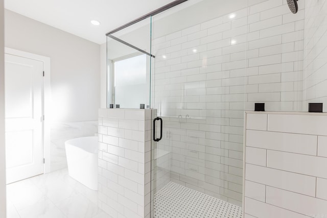 bathroom featuring tile walls and shower with separate bathtub