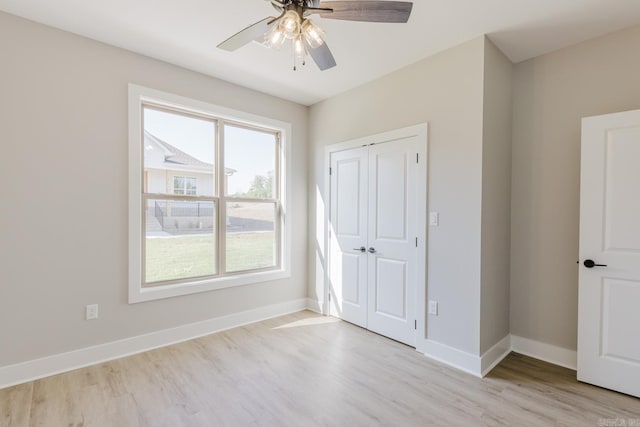 unfurnished bedroom with light hardwood / wood-style floors, ceiling fan, and a closet