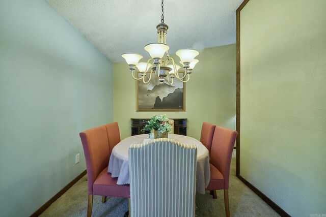 dining room featuring a chandelier, a textured ceiling, and light colored carpet