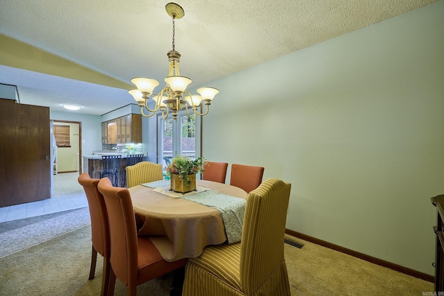 dining space with an inviting chandelier, light carpet, and a textured ceiling