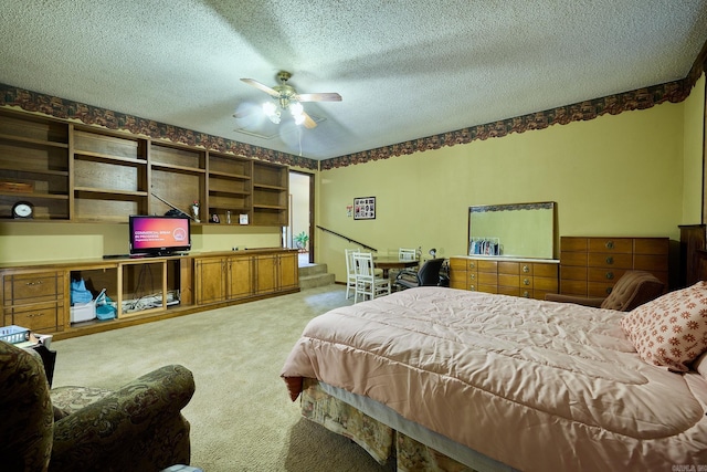 bedroom featuring a textured ceiling, light colored carpet, and ceiling fan