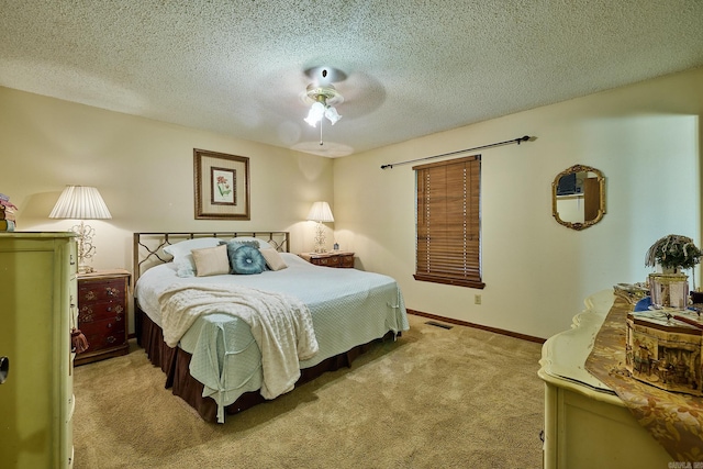 carpeted bedroom featuring a textured ceiling and ceiling fan