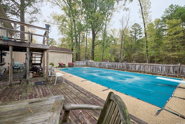 view of swimming pool with a diving board and a patio