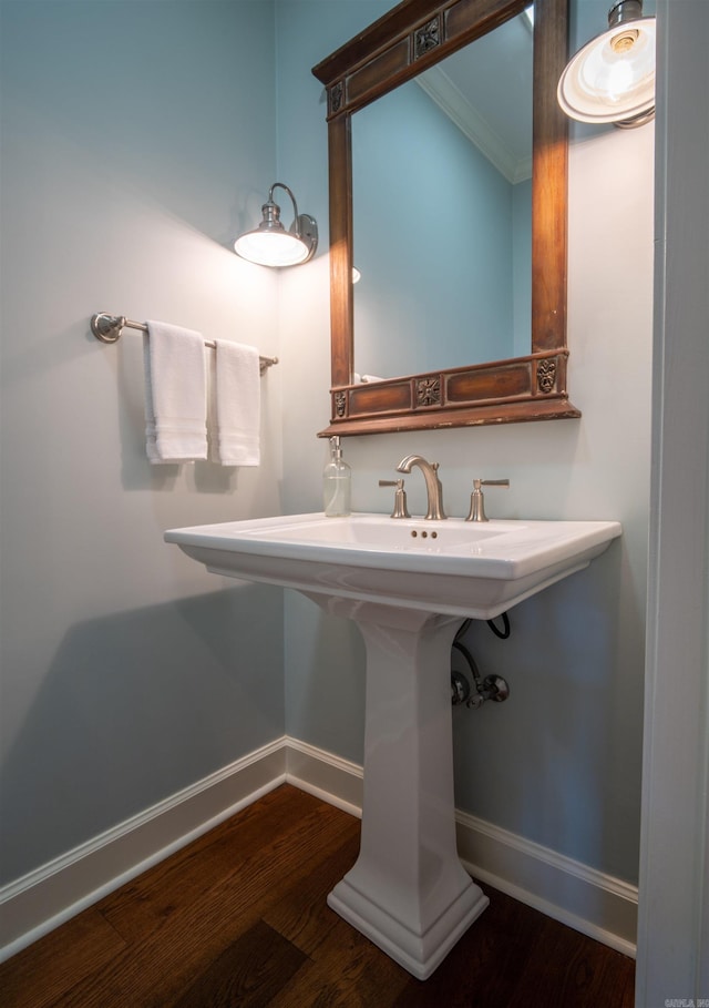 bathroom featuring sink, hardwood / wood-style flooring, and crown molding