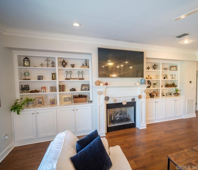 living room featuring dark wood-type flooring, built in features, and crown molding