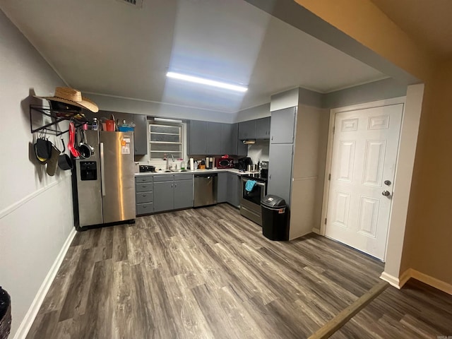 kitchen featuring gray cabinetry, appliances with stainless steel finishes, sink, and dark wood-type flooring