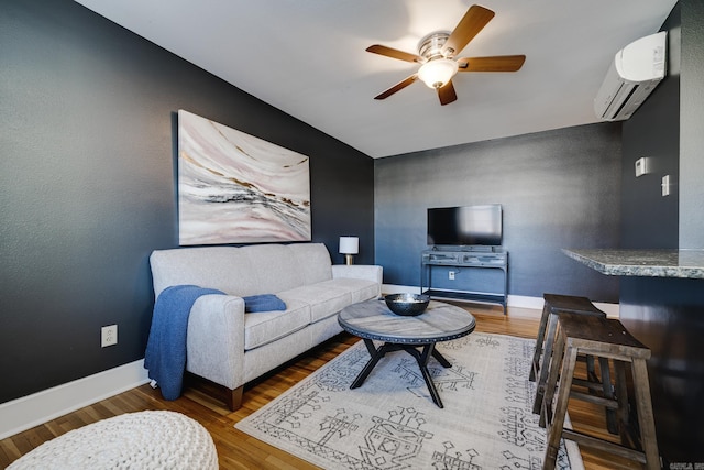 living room with hardwood / wood-style floors, ceiling fan, and a wall mounted air conditioner