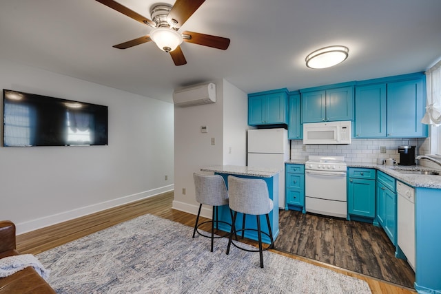 kitchen featuring blue cabinetry, white appliances, sink, and a wall mounted AC