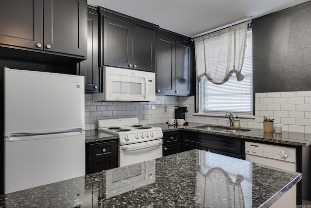 kitchen featuring dark stone counters, sink, white appliances, and backsplash