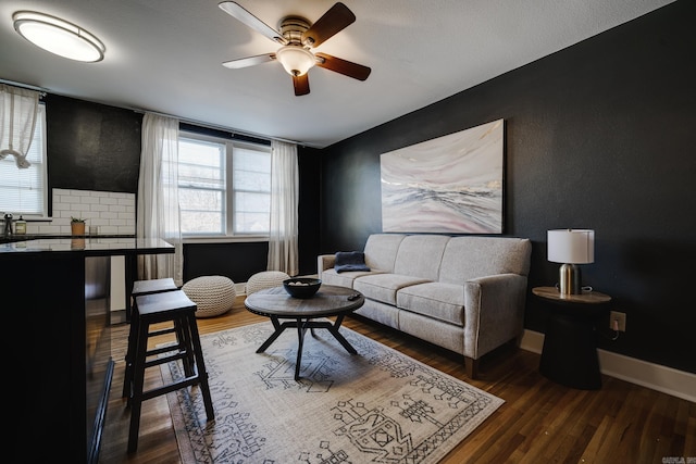 living room featuring dark wood-type flooring and ceiling fan