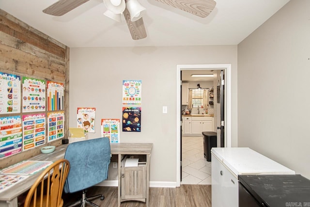 office with light hardwood / wood-style floors, sink, and ceiling fan