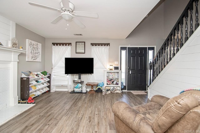 living room featuring wood-type flooring and ceiling fan