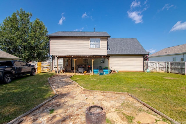 rear view of house with a lawn and a patio