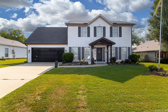 colonial inspired home with a garage and a front lawn