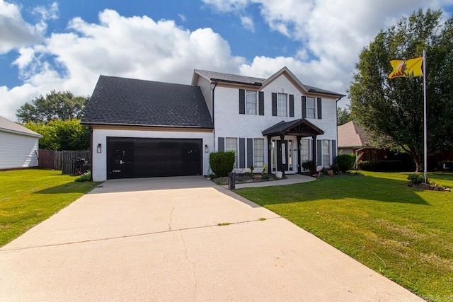 colonial home featuring a garage and a front lawn