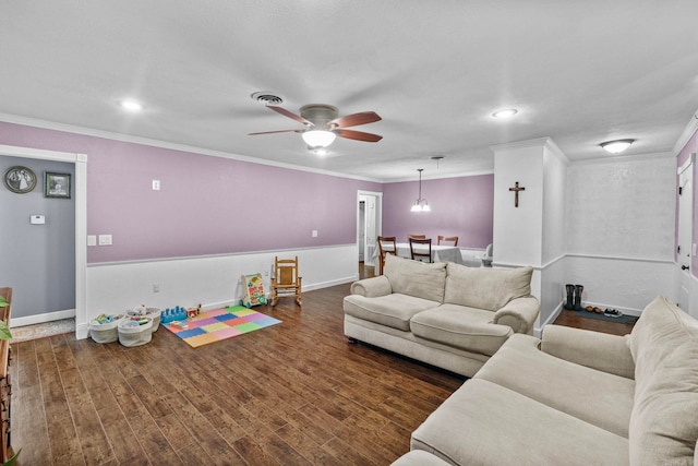 living room featuring ornamental molding, ceiling fan with notable chandelier, and dark hardwood / wood-style floors