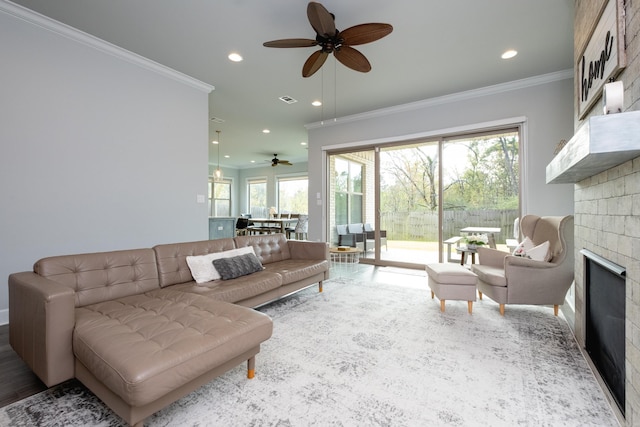 living room with hardwood / wood-style flooring, ceiling fan, and crown molding