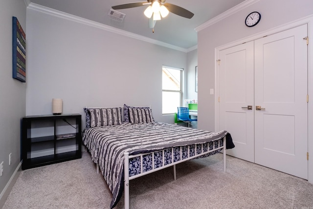 carpeted bedroom with ceiling fan, a closet, and ornamental molding