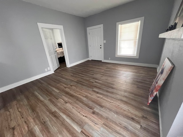 unfurnished living room with dark wood-type flooring