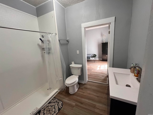 bathroom with walk in shower, wood-type flooring, a textured ceiling, and toilet