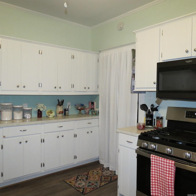 kitchen with white cabinets, dark wood-type flooring, crown molding, and stainless steel gas range