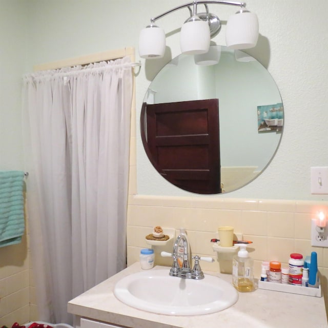 bathroom with vanity and tile walls