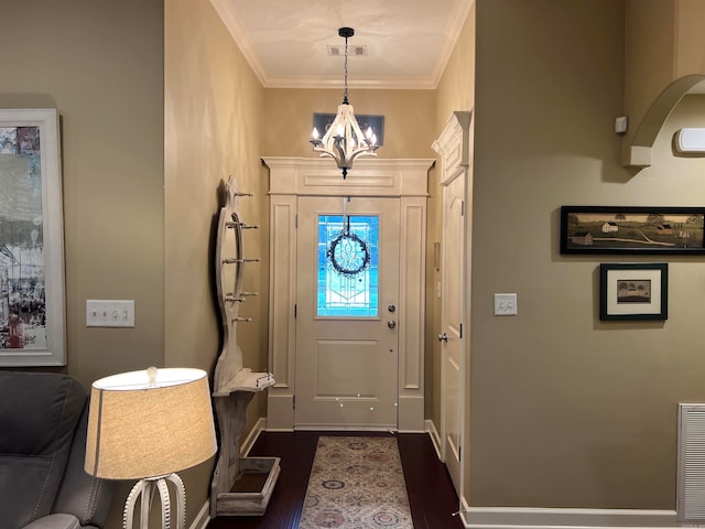 entryway with dark hardwood / wood-style flooring, an inviting chandelier, and crown molding