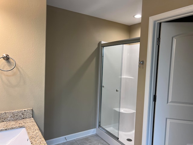 bathroom with vanity, tile patterned flooring, and a shower with door