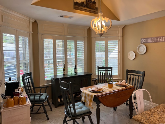 dining room featuring plenty of natural light, light tile patterned floors, and a notable chandelier