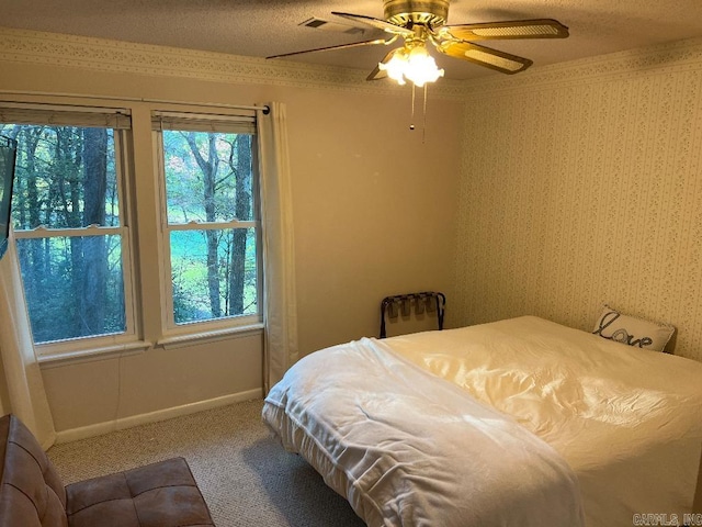 bedroom featuring ceiling fan, carpet floors, and a textured ceiling