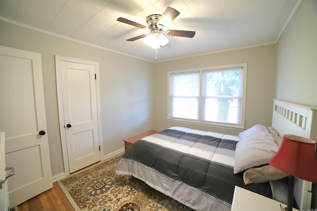 bedroom with wood-type flooring, ceiling fan, and crown molding