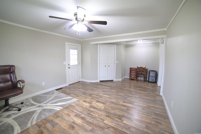 interior space with dark hardwood / wood-style flooring, ceiling fan, and crown molding