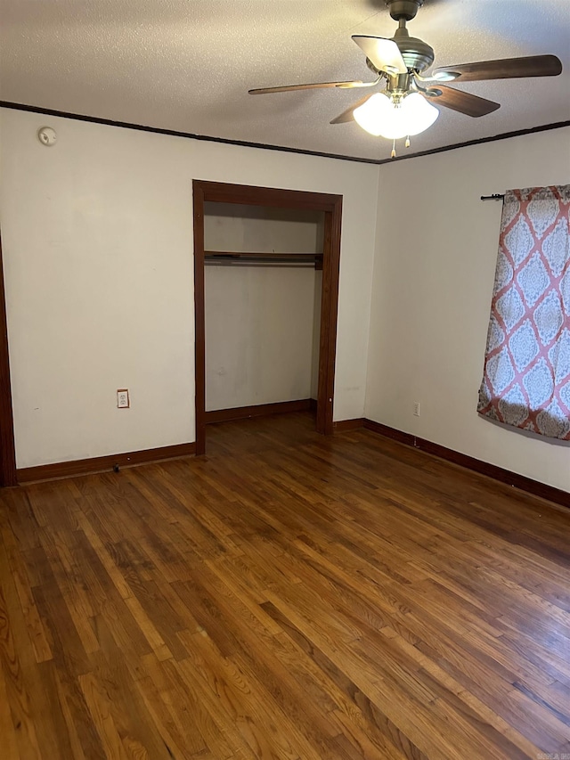 unfurnished bedroom featuring dark hardwood / wood-style flooring, ceiling fan, a closet, and a textured ceiling