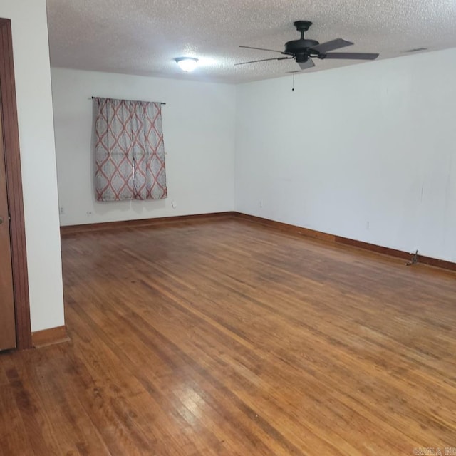 empty room featuring ceiling fan, hardwood / wood-style floors, and a textured ceiling