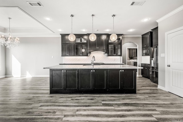 kitchen featuring stainless steel fridge with ice dispenser, wood-type flooring, sink, and an island with sink