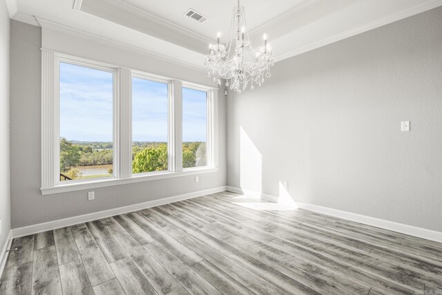 spare room featuring a wealth of natural light, wood-type flooring, and crown molding