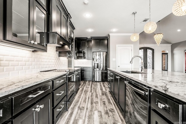 kitchen featuring light hardwood / wood-style floors, stainless steel appliances, decorative backsplash, sink, and decorative light fixtures