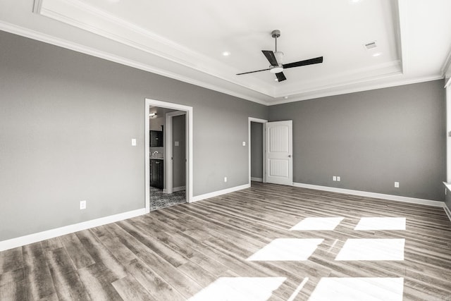 unfurnished bedroom with wood-type flooring, a raised ceiling, ceiling fan, and crown molding