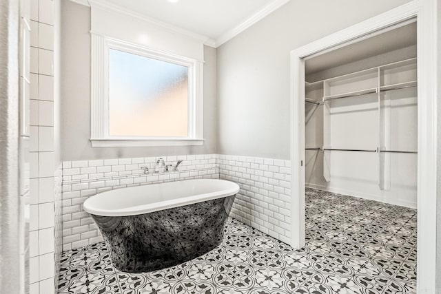 bathroom with tile walls, tile patterned flooring, a bathing tub, and ornamental molding