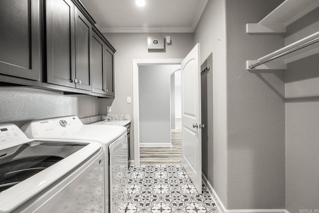 washroom with washing machine and clothes dryer, light tile patterned flooring, cabinets, and ornamental molding