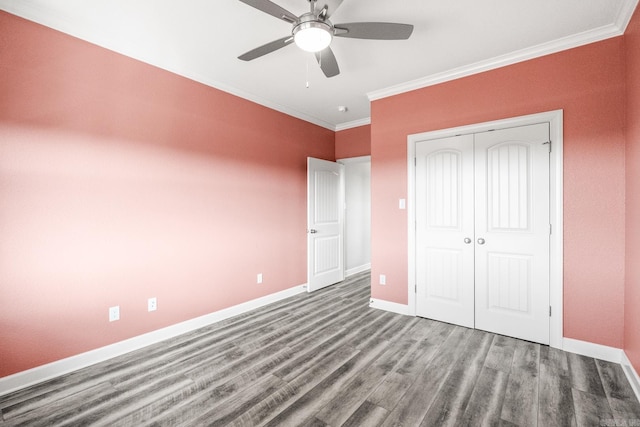 unfurnished bedroom featuring ornamental molding, a closet, wood-type flooring, and ceiling fan