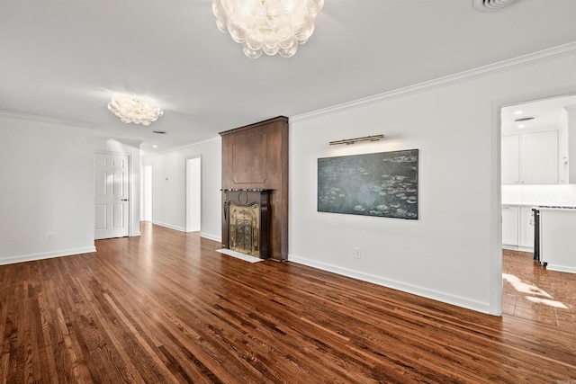 unfurnished living room featuring ornamental molding, dark wood-type flooring, and an inviting chandelier