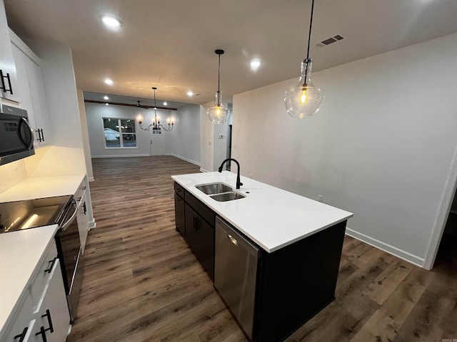 kitchen featuring stainless steel appliances, sink, a kitchen island with sink, white cabinets, and dark hardwood / wood-style flooring