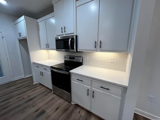 kitchen featuring stainless steel appliances, dark hardwood / wood-style floors, white cabinetry, and tasteful backsplash